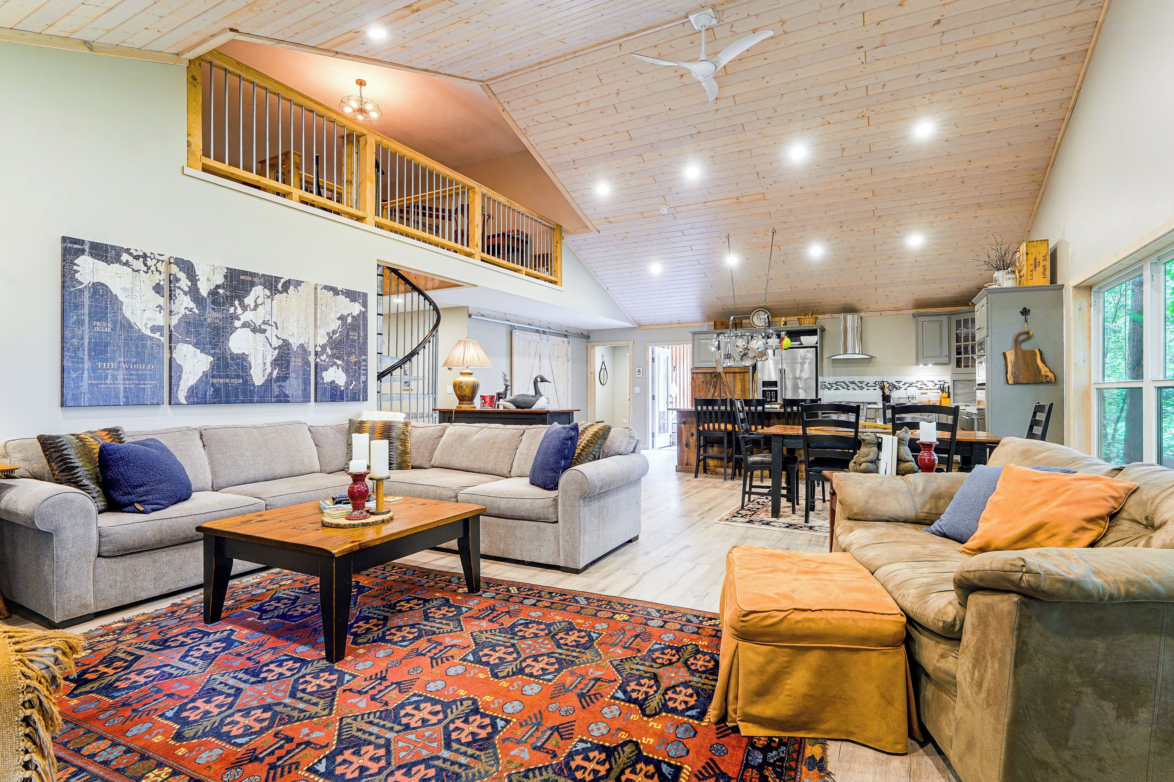 A spacious living area with a high ceiling, a dining area, and a kitchen.