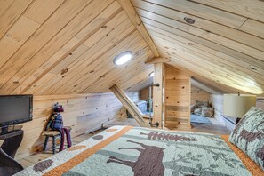A wooden attic bedroom with a bed, a TV, and a window. - Historic Wondervu Cabin Near Gross Reservoir (Golden)