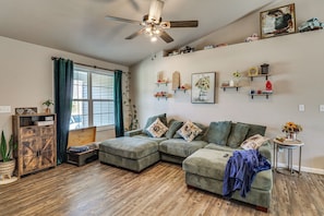 A living room with a sectional sofa, a ceiling fan, and a window with curtains. - Scenic St Claire Home: Deck + Spacious Yard (St Clair)
