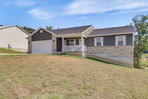 A two-story house with a front porch, garage, and a brick exterior. - Scenic St Claire Home: Deck + Spacious Yard (St Clair)