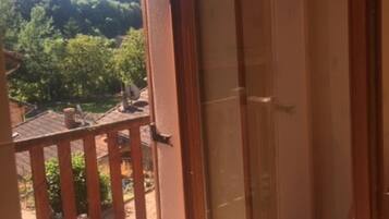 A room with a sliding glass door leading to a balcony.