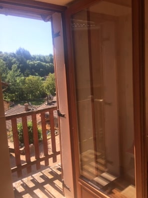 Una habitación con puerta de vidrio corredera que da a un balcón.