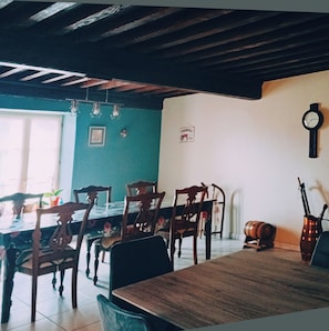 Un comedor con mobiliario de madera, un reloj en la pared y un letrero que dice 'FARMALL'.