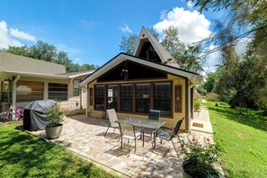 A house with a covered patio, a barbecue grill, and a lawn. - 'Good Vibes Cottage' Pool & Pier on Lake Louisa (Clermont)