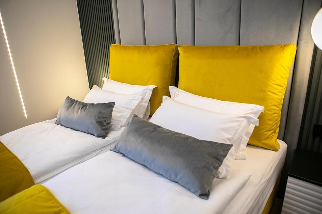 A double bed with two pillows, a headboard with vertical panels, and a bedside table.