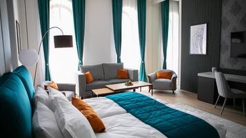 Una habitación de hotel moderna con una cama grande, un sofá, un escritorio y una silla.