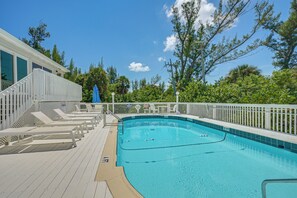 A swimming pool with a deck, surrounded by a white fence and trees. - Secluded Island Escape on Little Gasparilla Island (Placida)