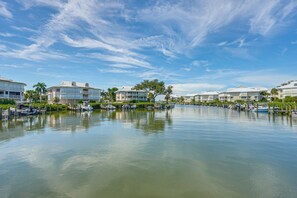 A marina with boats docked, surrounded by multi-story buildings with balconies. - Secluded Island Escape on Little Gasparilla Island (Placida)