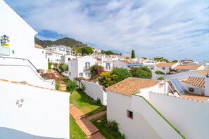 A residential area with white buildings, terracotta roofs, and a hillside in the background. - Villa in Nerja With Private Pool & Jacuzzi (Nerja)