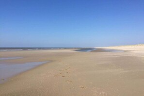 A beach with a wide sandy shore and calm water. - Holiday home with 3 bedrooms (Callantsoog)