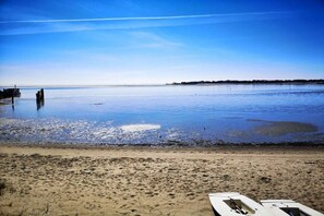 A beach with a calm sea, a pier, and a boat on the sand. - Holiday apartment in Nebel with swimming pool (Nebel)