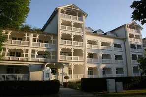 Um edifício com várias andares, varandas e uma entrada central.