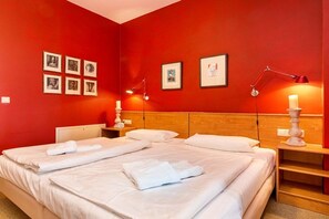 A hotel room with two beds, a wooden headboard, bedside tables with lamps, and framed pictures on the wall. - Holiday apartment in Binz with swimming pool (Binz)