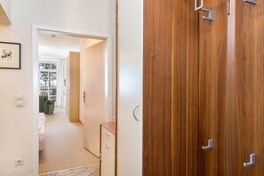 A hallway with a wooden wardrobe, a small cabinet, and a framed picture on the wall. - Holiday apartment in Binz with swimming pool (Binz)