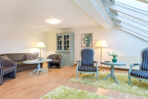 A living room with a sofa, armchairs, a table, and a cabinet. - 26 in the Villa Seasons (Binz)