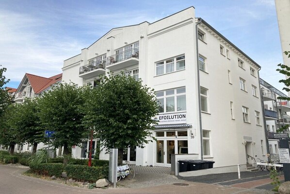 Ein weißes Gebäude mit einem Schild mit der Aufschrift 'EFOILUTION' und Balkonen.