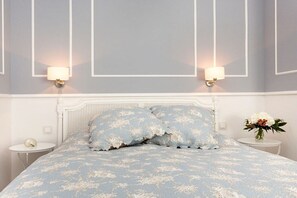 A bedroom with a bed, two bedside tables, and wall-mounted lamps. - Sea jewel in Villa Agnes (Binz)