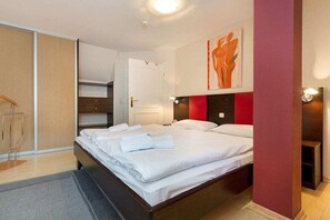 A hotel room with a large bed, a wardrobe, a bedside table, and a wall-mounted artwork. - Amber in the Villa Lucky (Binz)