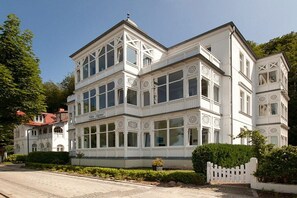 A multi-story building with a symmetrical facade, large windows, and decorative trim. - Sea greetings at Villa Agnes (Binz)
