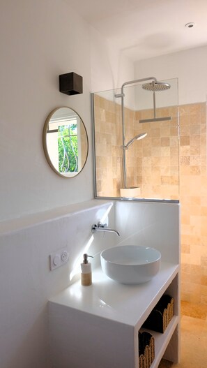 A modern bathroom with a white vanity, a round mirror, a glass-enclosed shower, and a view of greenery outside. - Maison Olivette: Provençal villa with a private pool, 6 bedrooms, and olive trees (Flayosc)