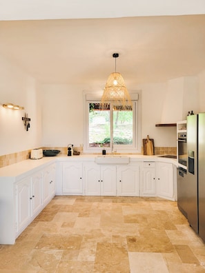 A modern kitchen with white cabinetry, a built-in oven, and a large window. - Maison Olivette: Provençal villa with a private pool, 6 bedrooms, and olive trees (Flayosc)