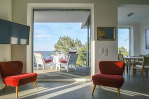 Ein modernes Interieur mit einem Balkon und Blick auf eine reizvolle Landschaft.