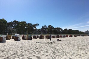 Ein Strand mit mehreren Reihen Strandkörben und einer Person, die darauf geht.
