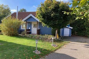 A single-story building with a blue exterior, a chimney, and a small porch. - Holiday home with 3 bedrooms (Boltenhagen)