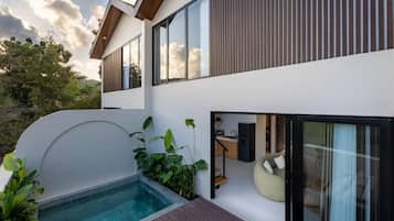 Een modern huis met twee verdiepingen, een zwembad, grote ramen en een balkon.