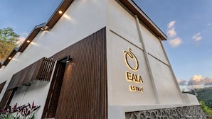 Un edificio moderno con un logotipo destacado y el nombre 'EALA ESTATE' en su fachada.