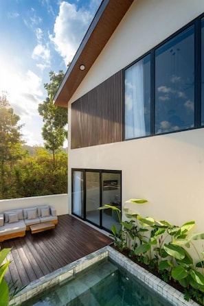 A modern house with a wooden deck, a swimming pool, and a large window. - Eala Estate (Pujut, Central Lombok Regency)