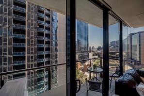 Un edifici de grattacels amb nombroses galeries, una galeria amb taula i cadires, i vista a la ciutat.