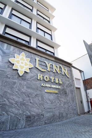 The exterior of the Lynn Hotel with a prominent sign and a decorative emblem. - Lynn Hotel Jombang (Jombang)
