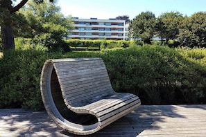 Een houten bank met een gebogen rugleuning, gelegen op een houten terras.