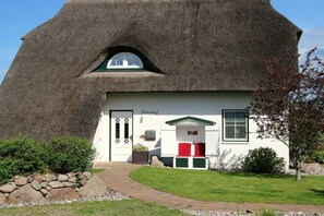 A thatched-roof building with a white facade, a door, and a window. - Holiday home in Usedom with 4 bedrooms (Zinnowitz)