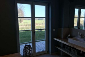 A bathroom with a large window, a sink, and a mirror. - Holiday home with 1 bedroom (Groß Schwansee)