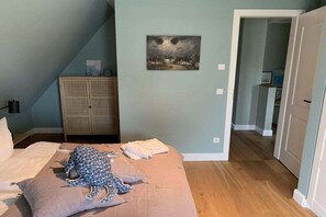 Ein Schlafzimmer mit einem Bett, einem Nachttisch, einem Kleiderschrank und einem Gemälde an der Wand.