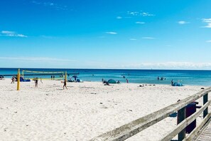 A beach with a volleyball net, people playing, and a wooden walkway. - Mobile home with 2 bedrooms (Großenbrode)