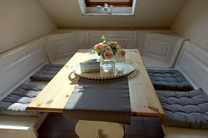 A corner seating area with a table, cushions, and a vase with flowers. - at the Kahlcke holiday farm 2 (Reinsbüttel)