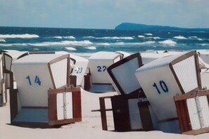 Beach chairs with numbers on them, arranged on a sandy beach with the ocean in the background. - 3-room holiday apartment with terrace (Zinnowitz)