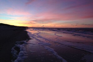 A beach with a sunset, waves, and a distant pier. - Holiday apartment with 2 bedrooms (Graal Müritz)