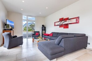 A modern living room with a grey sofa, a coffee table, and a flat-screen TV. - Seeperle Karlshagen with whirlpool (Karlshagen)
