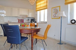 A dining area with a round table, chairs, and a lamp. - Baltic Melody with panoramic Baltic Sea views (Ostseebad Binz)