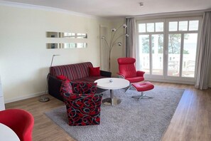 Ein modernes Wohnzimmer mit einer Couch, einem Sessel und einem runden Tisch.