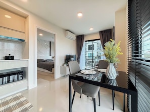 A modern hotel room with a dining area, a bed with a view, and an air conditioning unit. - 1-Bedroom Condo for Rent at Mira Monte, Soi Hua Hin 94 (Tambon Hua Hin)