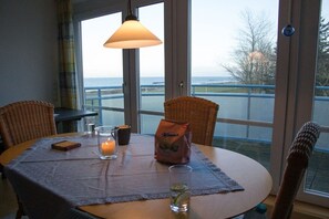 Une table à manger avec une bougie, un verre d’eau avec un quartier de citron vert et un sachet de collations.