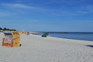 A beach with a lifeguard station, clear skies, and calm water. - Holiday apartment with 1 bedroom (Schönberger Strand)