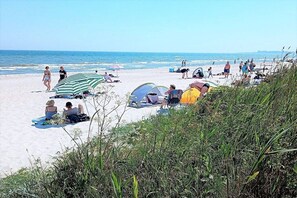 A beach with tents and people relaxing. - Holiday home with 2 bedrooms (Steinbergkirche)
