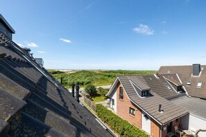 A residential area with multiple houses, each with distinct roof designs and a clear view of the surrounding landscape. - Strandkieker Achtern (St. Peter-Ording)