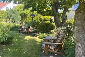 Ein Garten mit Holzbanken und einem Vogelhaus.